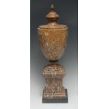 A Neo-Classical style fossil stone urn, pine cone finial, square plinth,