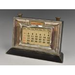 A George V silver desk calendar, rectangular aperture, ebonised base, 15cm wide,