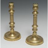 A pair of French Empire gilt brass table candlesticks, urnular sconces,