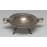 An Arts and Crafts style silver circular sweetmeat dish, each handle as a hand grasping a sphere,