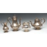 An Irish silver four piece tea service, engraved with vacant cartouches and foliate scrolls,
