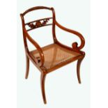 A Regency style mahogany elbow chair, arched ropetwist cresting rail, scroll arms, cane seat,
