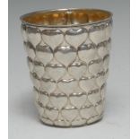 A German silver tapered cylindrical beaker, profusely chased with rows of heart motifs,