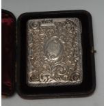 A Victorian silver rounded rectangular aide memoir, embossed with flowers and scrolling foliage,