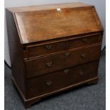 A George III oak bureau, fall front enclosing pigeon holes and small drawers,