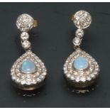 A pair of opal and diamond drop earring, each with a central opal pear cabochon,