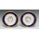 A pair of Royal Crown Derby shaped circular plates, painted by Charles Harris, one signed CH,