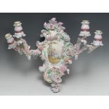 A German Rococo Revival porcelain cartouche-shaped wall sconce, painted with a courting couple,
