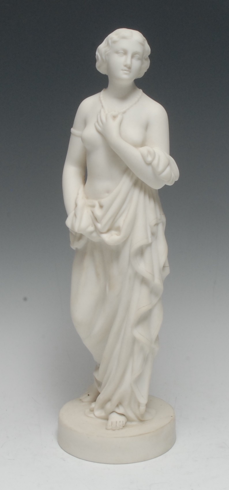 A Belleek Parian figure, Affection, she stands scantily draped, holding her necklace, circular base,