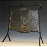 An Arts and Crafts copper and wrought iron fire screen, repousse chased with a galleon,