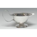 An Arts and Crafts silver jug, wavy everted rim, meandering loop handle with forked terminals,