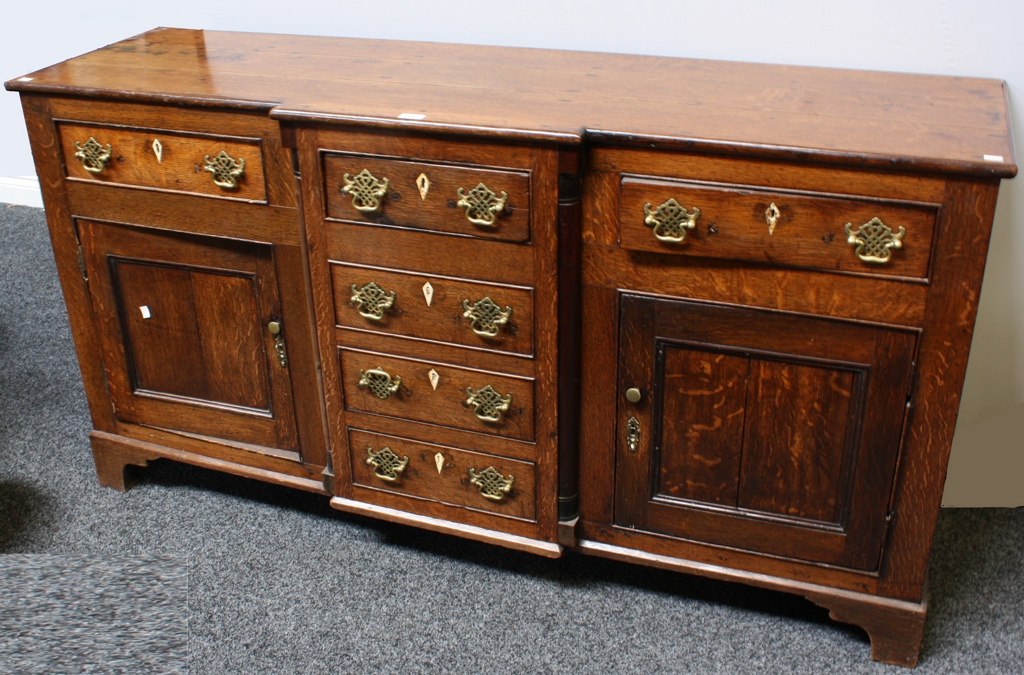 A George III oak low breakfront dresser, slightly oversailing top above a row of four drawers,