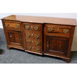 A George III oak low breakfront dresser, slightly oversailing top above a row of four drawers,