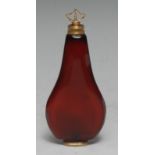 An 18th century gold mounted ruby glass flattened pear shaped scent bottle, inverted axehead finial,