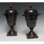 A pair of Regency style bronzed two handled urns and covers, pineapple finials, half girdle,