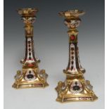 A pair of Royal Crown Derby 1128 pattern Castleton candlesticks, dolphin to angles,