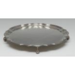 An Elizabeth II silver shaped circular salver, of George II design, plain field, wrapped knurl feet,