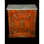 A French Empire gilt metal mounted mahogany pier cabinet, rectangular marble top above a panel door,