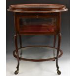 An unusual Edwardian mahogany drinks waiter's trolley, the oval top with lift-off serving tray,