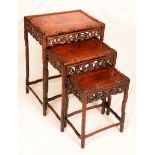 A Chinese hardwood nest of three occasional tables, rectangular panel tops,