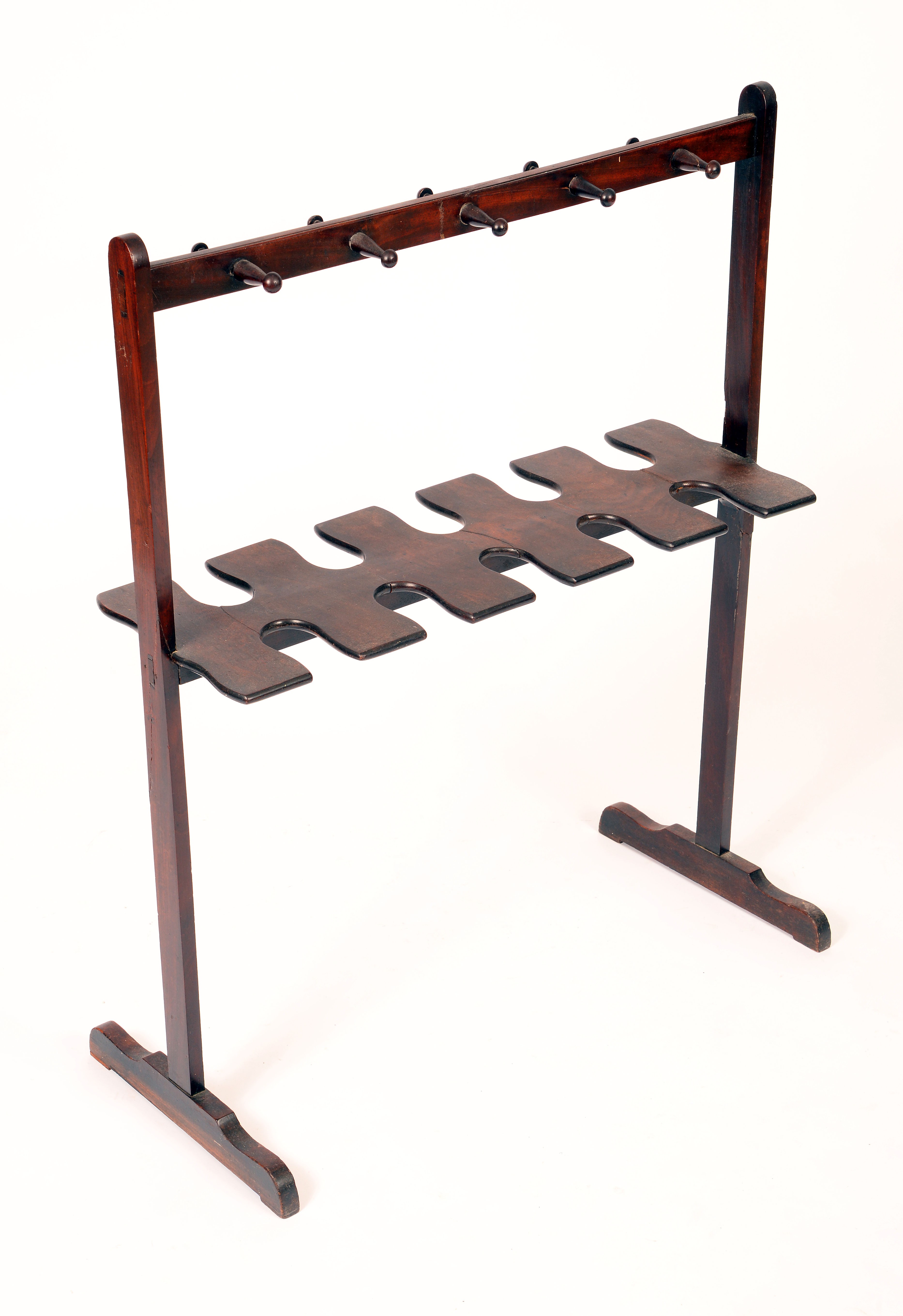 A 19th century mahogany riding boot and whip rack, turned pegs and shaped apertures, sledge base,