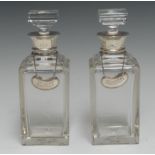 A pair of Art Deco silver mounted clear glass square spirit decanters, square stoppers,