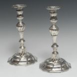 A pair of George II cast silver table candlesticks, spirally fluted knopped baluster pillars,