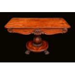 A William IV rosewood library table, rounded rectangular top above a deep shaped frieze,