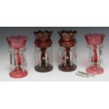 A pair of Victorian ruby glass decanters, with clear glass prismatic lustres, 27cm high, c.