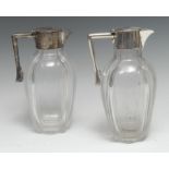 A pair of Edwardian silver mounted clear glass claret jugs, hinged covers, angular handles,