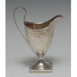 A George III silver helmet shaped cream jug, punch beaded border,