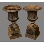 A pair of Victorian cast iron fluted campana garden urns, square bases, 47cm high, c.