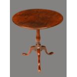 A George III mahogany tripod occasional table, circular tilting top, slender baluster pillar,