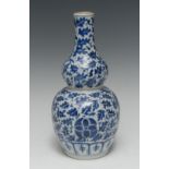 A Chinese porcelain double-gourd vase, painted in underglaze blue with a peonies and leafy scrolls,