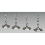 A set of four George I style cast silver octagonal tapersticks, knopped stems, spreading bases,