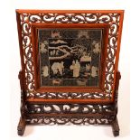 A Chinese hardwood screen, pierced and carved throughout with scrolling clouds,