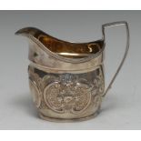 A George III silver boat shaped cream jug, later chased with flowers and C-scrolls,