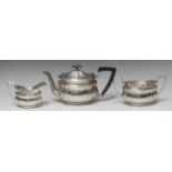 A George V silver three piece shaped oval tea service, comprising teapot, milk jug and sugar basin,