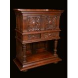 A Flemish oak side cabinet, moulded top above a pair of panel doors carved in relief with strapwork,
