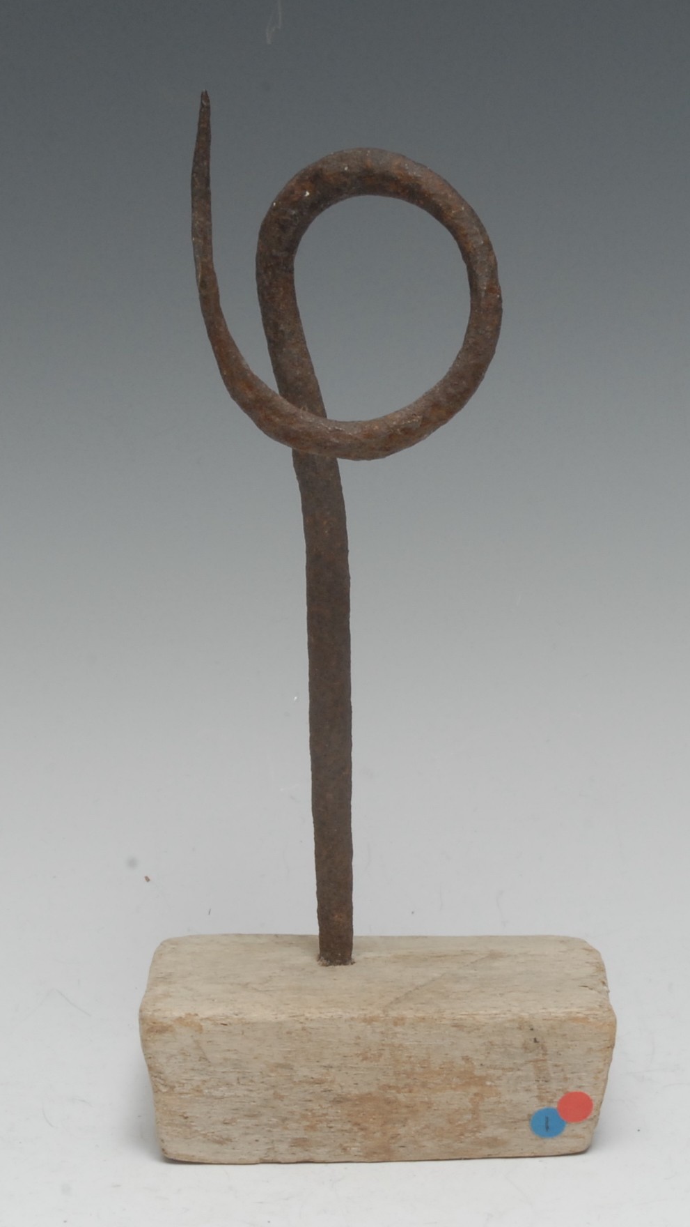 A primitive iron pricket candlestick, wrought in a simple loop, softwood base, 24.