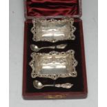 A pair of Victorian shaped rectangular open salts, embossed with swags, pierced rims, bun feet,