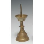A 16th century brass pricket candlestick, deep dished wax pan, knopped stem, domed circular foot,