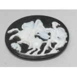 A carved black and white oval cameo panel, Neoclassical Warriors and rearing Horse,