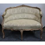 A 19th century French sofa, curved cresting rail carved with fruiting foliage, shells and C-scrolls,