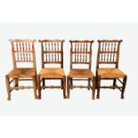 A set of eight elm kitchen chairs with shaped cresting rails, rush seats, turned stretcher,
