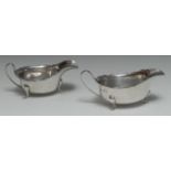 A matched pair of George V silver sauce boats, shaped everted rims, scroll handles, pad feet,