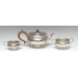 A George V silver three piece tea service, comprising teapot, milk jug and sugar basin,