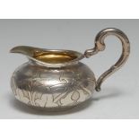 An early 19th century German silver cream jug, chased with leafy strapwork, scroll handle,