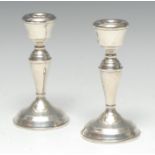 A pair of Elizabeth II silver candlesticks, bell shaped sconces, tapered pillars,