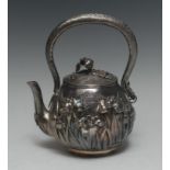 A Japanese silver globular tea kettle, in relief with irises on a planished ground,